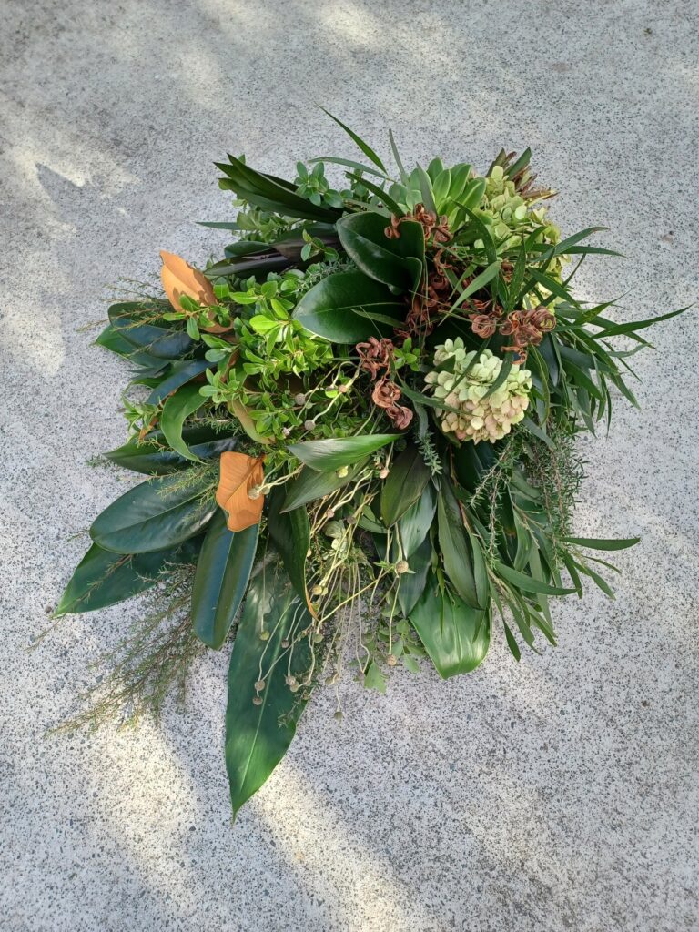 Kin Florist foam-free, foliage casket sheaf, with a mix of different locally grown greenery types and textures, for a local Matakana funeral.