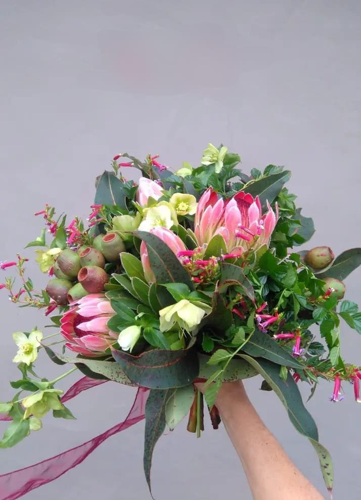 Kin Florist Matakana pretty seasonal winter wedding bouquet with proteas, hellebores and eucalyptus, all local and sustainable, and a rustic garden style.