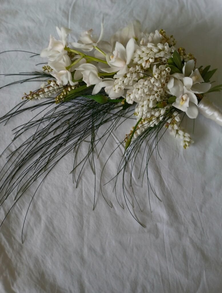 Kin Florist Matakana wedding bouquet with white orchids and hanging foliage. The bouquet is designed to gracefully drape for a luxurious, elegant look.